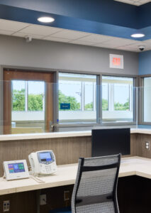 Healthcare nurse station featuring integrated communication systems, master station controls, and security camera reflecting early-stage technology and security planning in healthcare construction